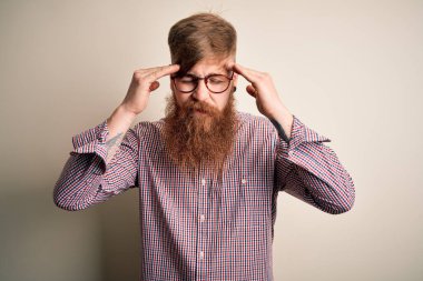 Yakışıklı, kızıl saçlı, sakallı, gözlüklü, soyutlanmış arka planda, başı ağrıyan bir İrlandalı iş adamı. Migren ağrısı..