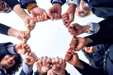 Bir grup işçi ofiste yumruk tokuşturuyor.