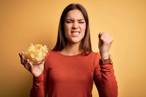 Joven Hermosa Morena Sosteniendo Tazón Con Patatas Fritas Sobre Fondo —  Fotos de Stock