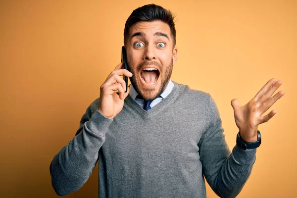 Jovem Homem Bonito Conversando Smartphone Sobre Fundo Amarelo Muito Feliz — Fotografia de Stock