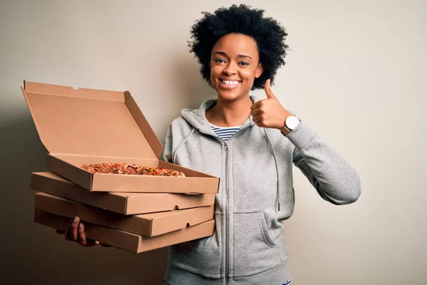若いですアフリカ系アメリカ人アフロ女性とともに巻き毛保持デリバリーボックスでイタリアのピザ幸せなで大きな笑顔を行いますOkサイン 指で親指アップ 優れたサイン — ストック写真