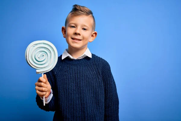 Jovem Garoto Caucasiano Comendo Doce Pirulito Sobre Fundo Isolado Azul — Fotografia de Stock