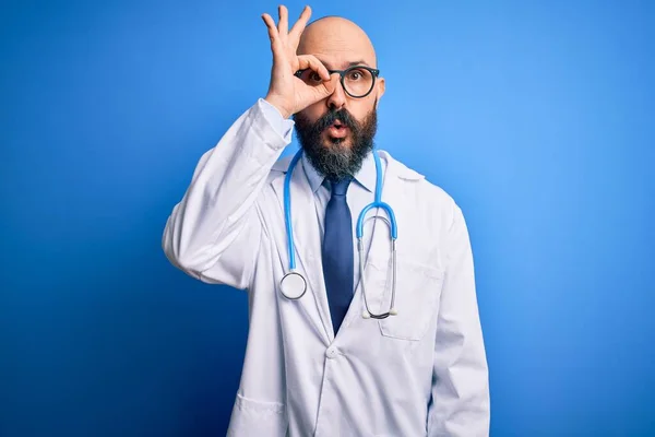 英俊的秃头医生 留着胡子 戴着眼镜 带着听诊器 背景是蓝色的 难以置信的表情 — 图库照片