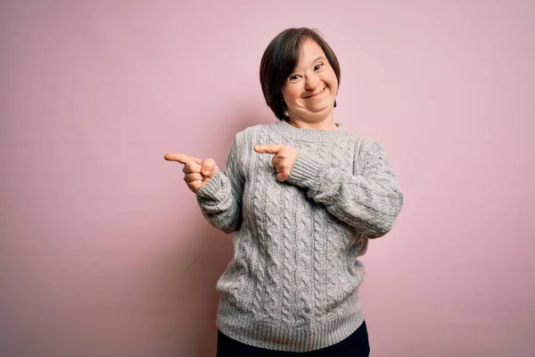 증후군 환자가 스웨터를 배경웃으며 손가락을 옆으로 향하고 카메라를 있습니다 — 스톡 사진