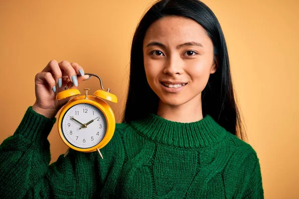 Junge Schöne Chinesin Hält Vintage Wecker Über Isoliertem Gelben Hintergrund — Stockfoto