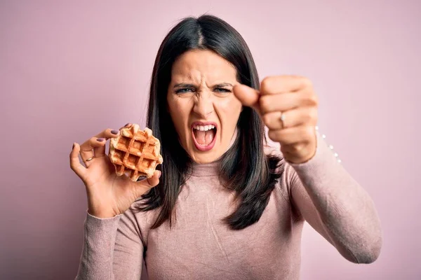 若いですブルネット女性とともに青い目食べる甘いワッフルのために朝食上の白い背景不満とフラストレーション叫びとともに怒り 狂気と叫びとともに手を上げ 怒りの概念 — ストック写真