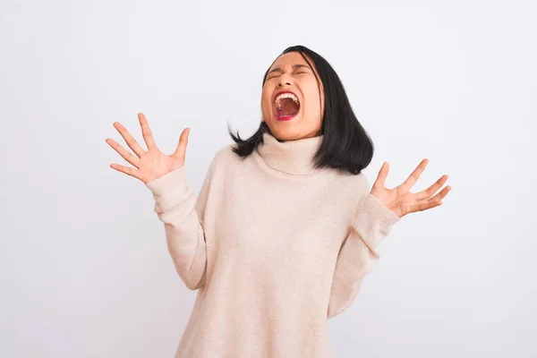 年轻的中国女人穿着高领毛衣 站在孤零零的白色背景上欢庆胜利的狂喜和疯狂 举手表决 紧闭双眼兴奋地尖叫着 赢的概念 — 图库照片