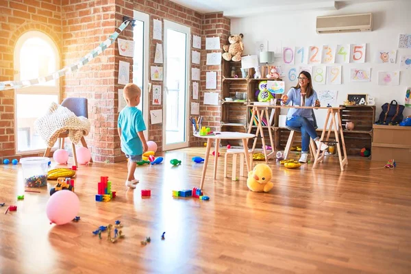 Jovem Criança Caucasiana Brincando Playschool Com Professor Jovem Sentada Mesa — Fotografia de Stock