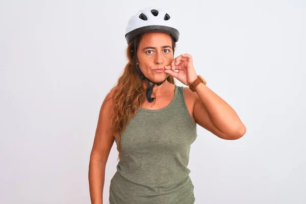 中年成熟的骑自行车的女人戴着安全帽 戴在孤立的背景嘴和嘴唇上 用手指紧闭着拉链 秘密和沉默 禁忌说话 — 图库照片