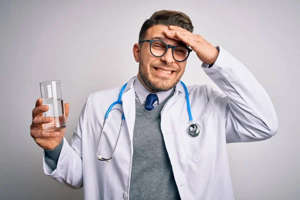 Jovem Médico Vestindo Casaco Médico Segurando Copo Água Doce Sobre — Fotografia de Stock