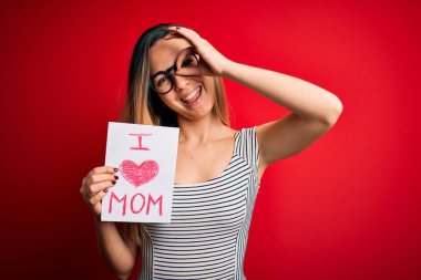 Elinde aşk dolu bir kağıt tutan güzel bir kadın. Anneler gününü mutlu bir gülümsemeyle kutluyor. Tamam.