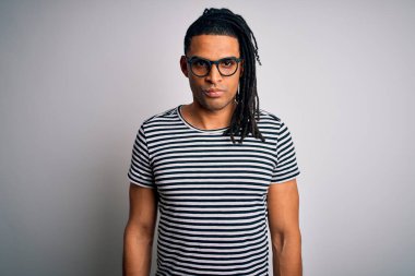 Rasta giyen, çizgili tişört giyen, gözlüklü, şüpheci ve sinirli, sorun yüzünden üzgün olan yakışıklı Afro-Amerikan bir adam. Negatif kişi.