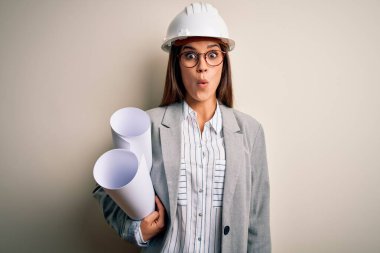 Güvenlik kaskı takan genç, güzel bir mimar ve elinde gözlükler. Şok geçirmiş, şaşırmış ve korku ifadesinden korkan bir kadın.