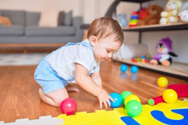 Anaokulunda küçük renkli toplarla oynayan güzel bir çocuk.