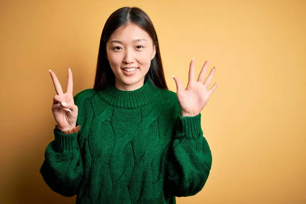 Молодая Красивая Азиатская Женщина Зеленом Зимнем Свитере Желтом Изолированном Фоне — стоковое фото