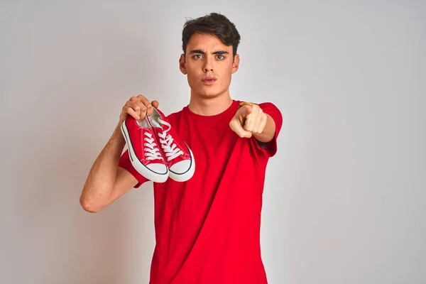 Ragazzo Adolescente Che Tiene Moda Scarpe Ginnastica Casual Sfondo Rosso — Foto Stock