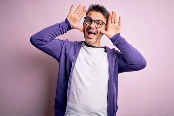 Jovem Homem Bonito Vestindo Camisola Roxa Óculos Sobre Fundo Rosa — Fotografia de Stock