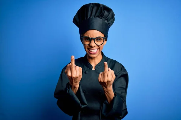 Mladá Africká Americká Kuchařka Uniformě Klobouku Modrém Pozadí Ukazující Prostředníček — Stock fotografie