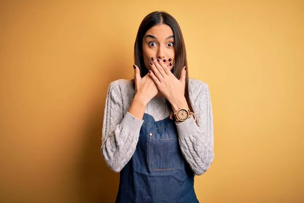 Junge Schöne Bäckerin Schürze Uniform Kocht Über Gelbem Hintergrund Schockiert — Stockfoto