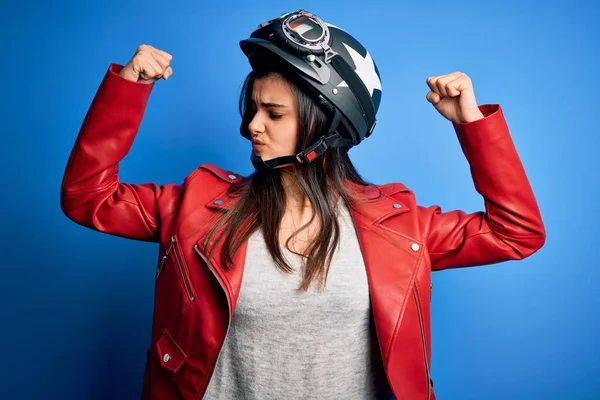 腕の筋肉を示すオートバイのヘルメットとジャケットを身に着けている若い美しいブルネットのオートバイの女性は誇りに思って笑っている フィットネスコンセプト — ストック写真