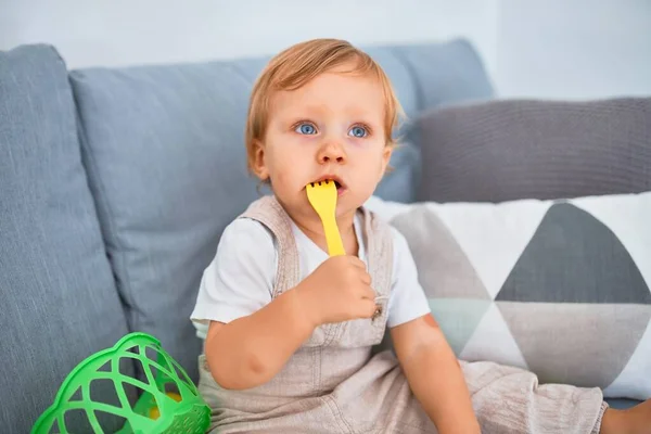 Bedårande Blont Barn Sitter Soffan Leker Med Plast Måltider Leksaker — Stockfoto