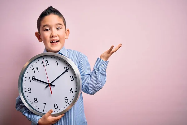 Niño Pequeño Sosteniendo Reloj Gran Minuto Sobre Fondo Rosa Aislado — Foto de Stock