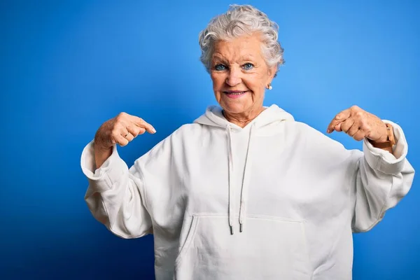 Senior Mooie Sportieve Vrouw Draagt Witte Sweater Geïsoleerde Blauwe Achtergrond — Stockfoto