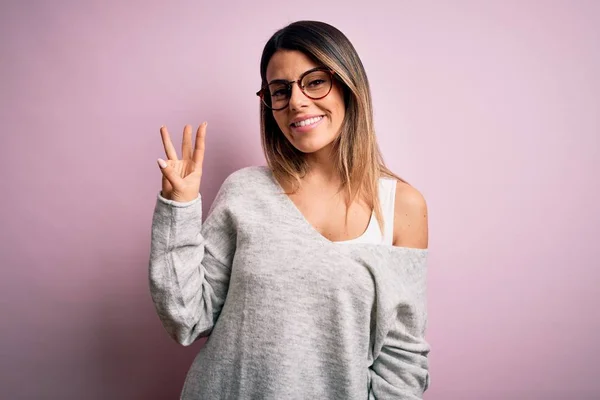 Joven Hermosa Morena Con Suéter Casual Gafas Sobre Fondo Rosa —  Fotos de Stock