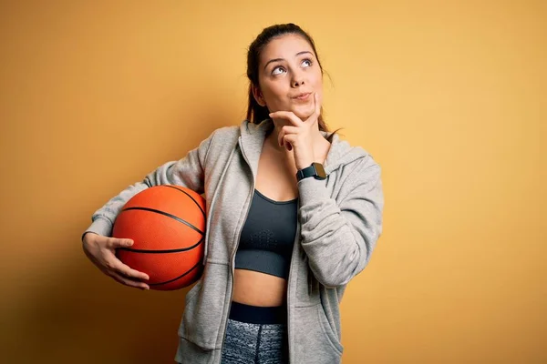 Joven Hermosa Deportista Morena Sosteniendo Pelota Baloncesto Sobre Fondo Amarillo —  Fotos de Stock