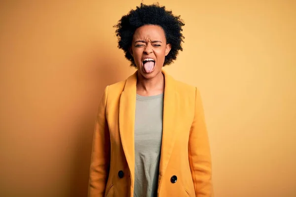 Молодая Красивая Афро Американка Вьющимися Волосами Желтой Куртке Торчащей Языком — стоковое фото