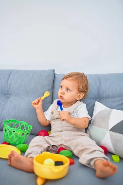 Adorable Niño Rubio Sentado Sofá Jugando Con Juguetes Comidas Plástico —  Fotos de Stock