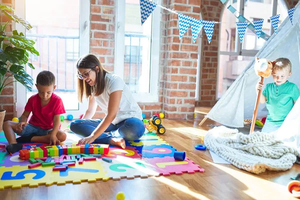 Junge Schöne Lehrerin Und Kleinkinder Spielen Kindergarten Mit Viel Spielzeug — Stockfoto