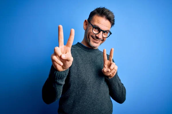 Homem Bonito Jovem Vestindo Camisola Casual Óculos Sobre Fundo Azul — Fotografia de Stock