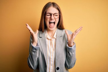 Ceket ve gözlük takan genç, güzel, kızıl saçlı kadın sarı arka planda çılgın ve başarıyı kutluyor kollarını kaldırmış, gözlerini kapatmış heyecanlı çığlıklar atıyor. Kazanan konsept