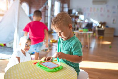 Anaokulunda bir sürü oyuncakla oynayan sevimli çocuklar.