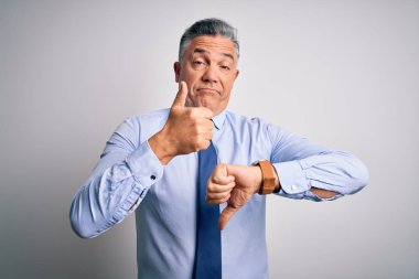 Orta yaşlı, yakışıklı, gri saçlı, şık gömlekli ve kravatlı bir iş adamı baş parmaklarını kaldırıyor, anlaşmazlık ve anlaşma ifadesi takınıyor. Çılgın çatışma