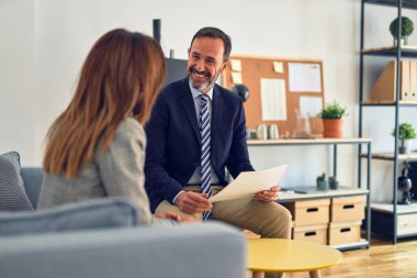 Mutlu ve kendinden emin gülümseyen iki orta yaşlı iş adamı. Ofiste evrakları tutarken gülümseme ile birlikte çalışmak.