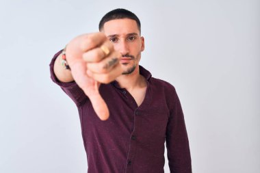Tecrit edilmiş arka planda duran yakışıklı genç bir iş adamı mutsuz ve kızgın görünüyor. Reddedilmiş ve olumsuz bir hareket sergiliyor. Kötü ifade.