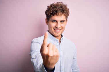 Sarışın, kıvırcık saçlı, çizgili tişörtlü, beyaz arka planda genç, yakışıklı bir adam.