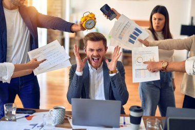 Group of business workers working together. Partners stressing one of them at the office