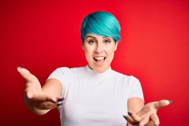 Mavi saçlı, kırmızı arka planda sıradan tişörtler giyen genç ve güzel bir kadın gülümseyen, yardım eli uzatan ve kabul gören eller sunuyor..