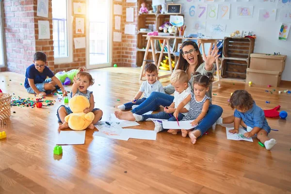 漂亮的老师和一群幼儿在幼儿园玩很多玩具 — 图库照片