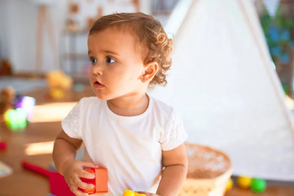 可爱的幼儿在幼儿园的许多玩具周围玩积木游戏 — 图库照片