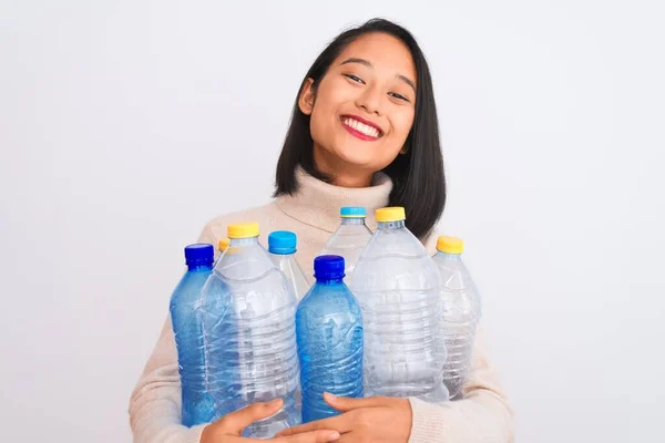 年轻美丽的中国女人把塑料瓶用在与世隔绝的白色背景上 脸上挂着幸福的表情 脸上挂着自信的微笑 露出牙齿 — 图库照片