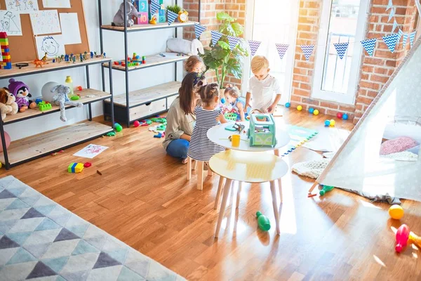 Mooie Leraar Groep Peuters Spelen Rond Veel Speelgoed Kleuterschool — Stockfoto