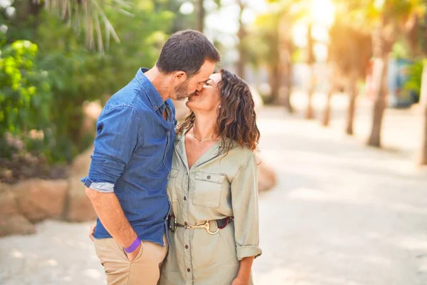一对年轻漂亮的夫妇在公园里开心而自信地微笑着 笑着站在那里拥抱和亲吻 — 图库照片
