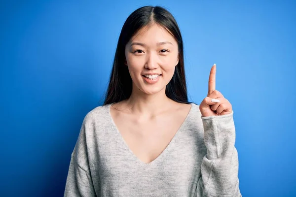 Junge Schöne Asiatische Frau Lässigem Pullover Steht Vor Blauem Hintergrund — Stockfoto