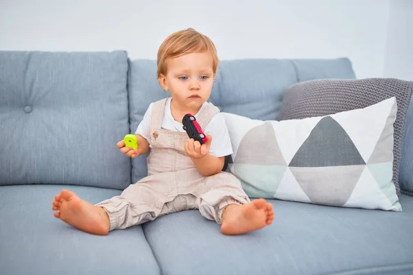 Entzückende Blonde Kleinkind Sitzt Auf Dem Sofa Hause Spielen — Stockfoto