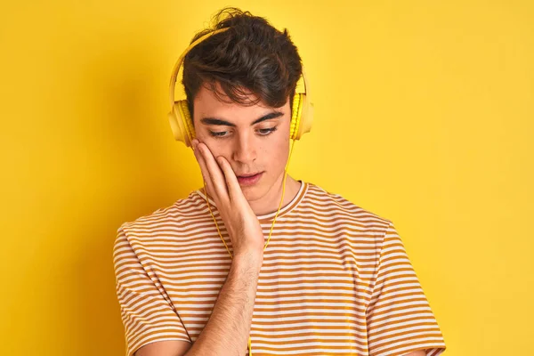 Adolescente Niño Usando Auriculares Sobre Fondo Amarillo Aislado Pensando Que — Foto de Stock
