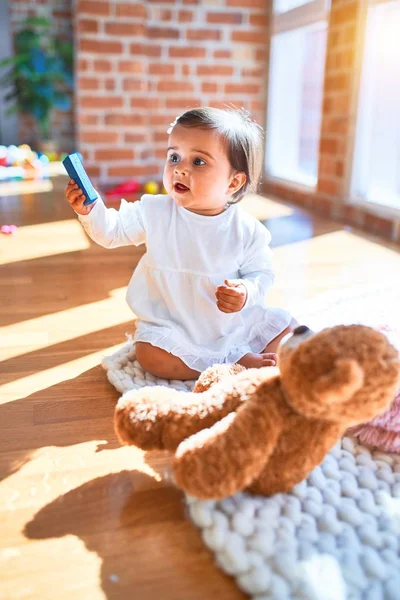 在五彩缤纷的玩具旁的幼儿园里快乐的漂亮婴儿 — 图库照片